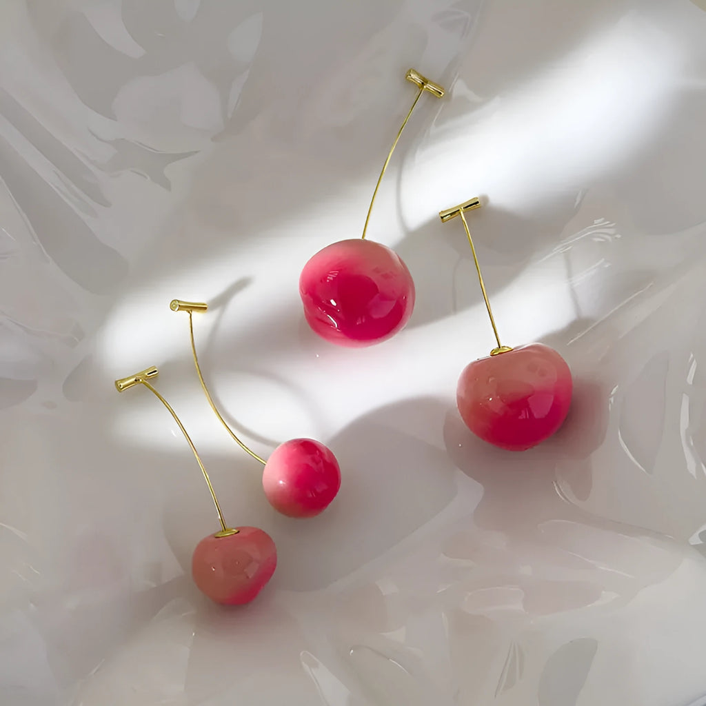 A pair of acrylic peach-shaped earrings on copper findings, shown in small and large size options.