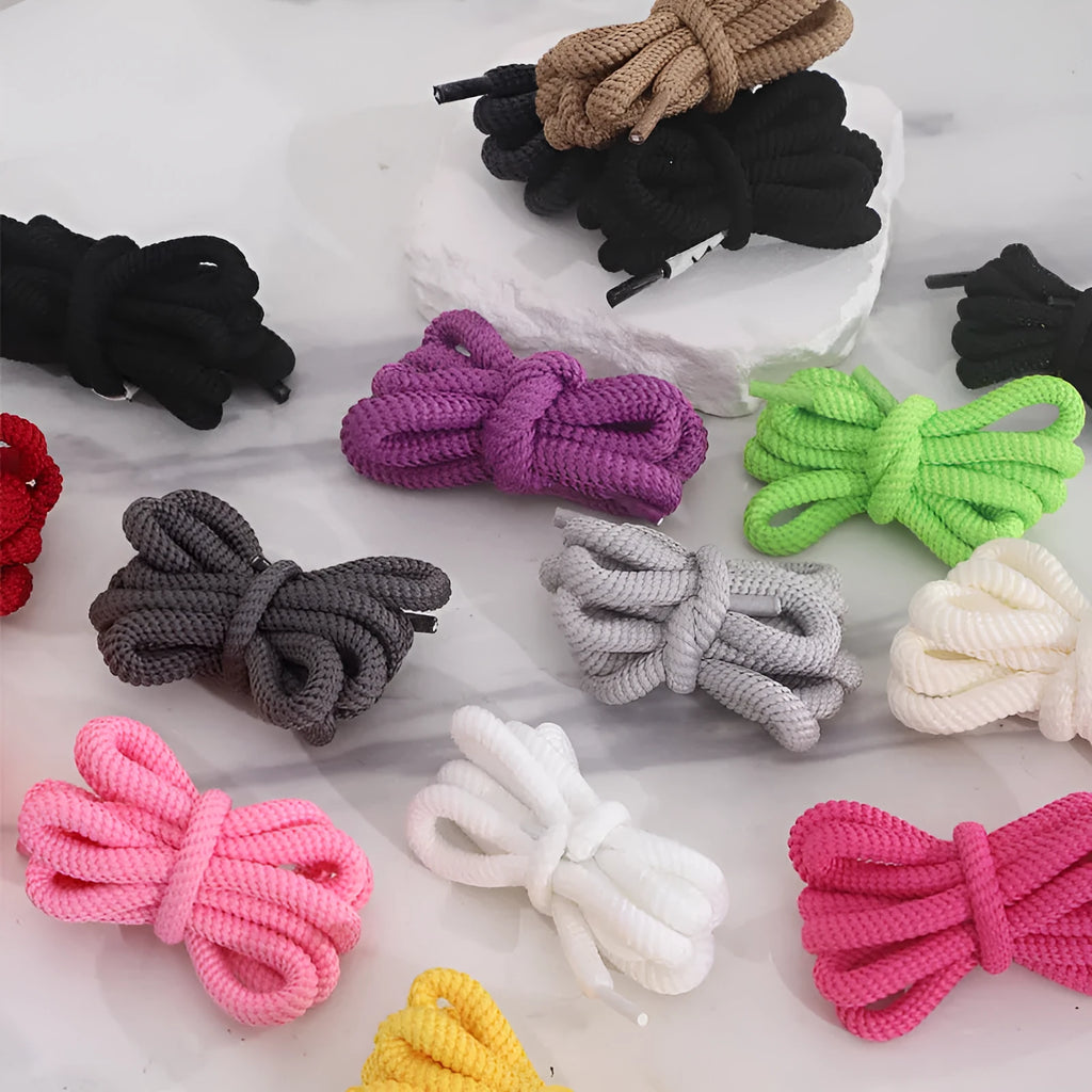 Oval round shoelace in multiple colours showing 1.0cm width, next to a sneaker.