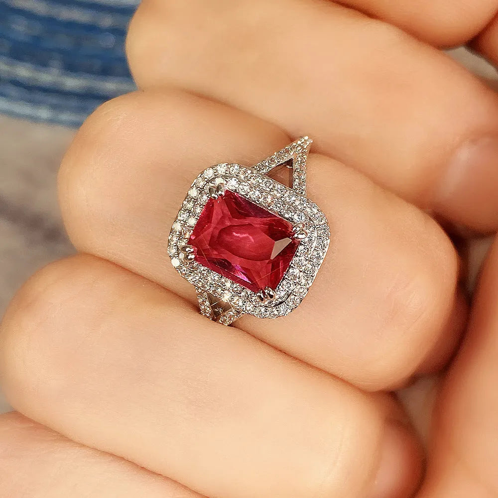 Women's red copper square ring with rhinestone geometric design on a finger.