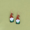 A pair of cartoon Santa Claus acrylic fashion earrings on a red background.