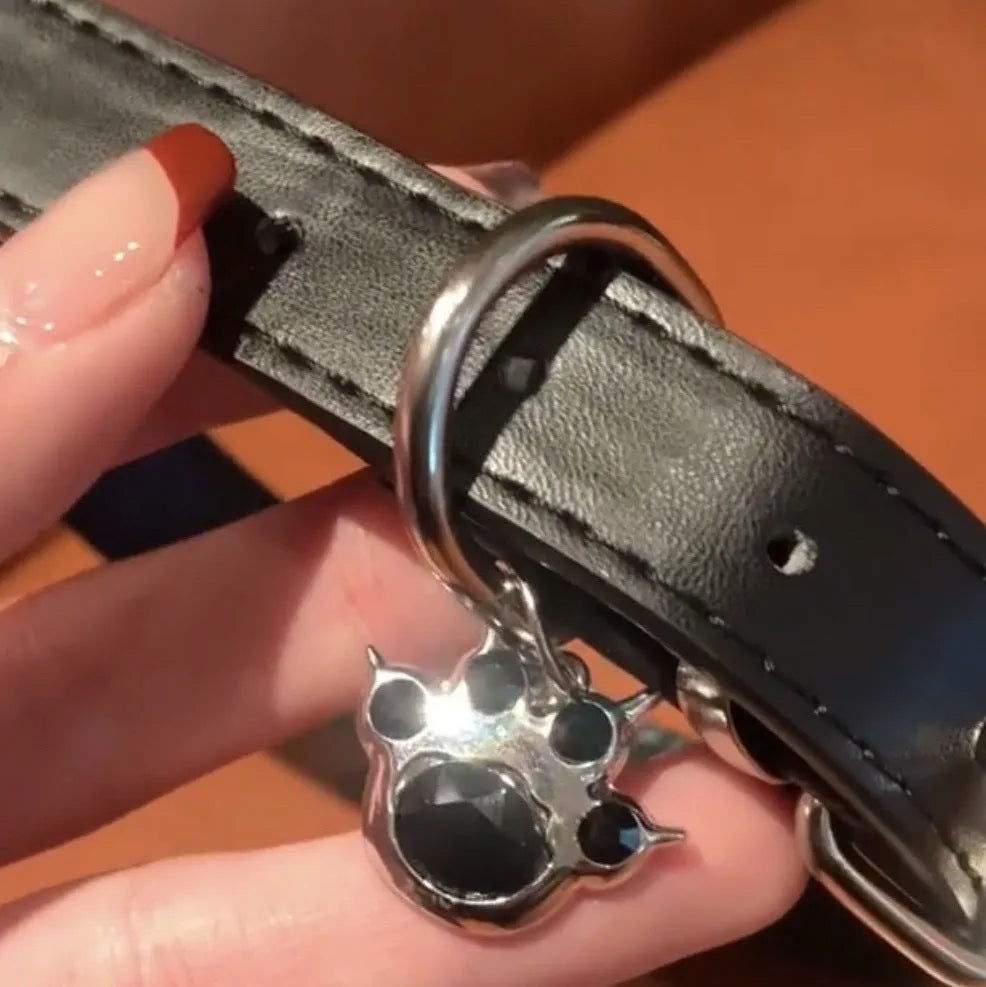 Black leather dog collar with bell pendant showing adjustable design from 21cm to 50cm perimeter