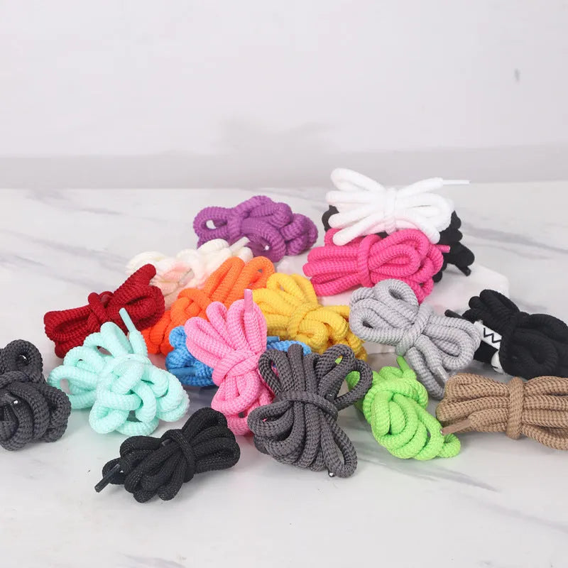 Oval round shoelace in multiple colours showing 1.0cm width, next to a sneaker.
