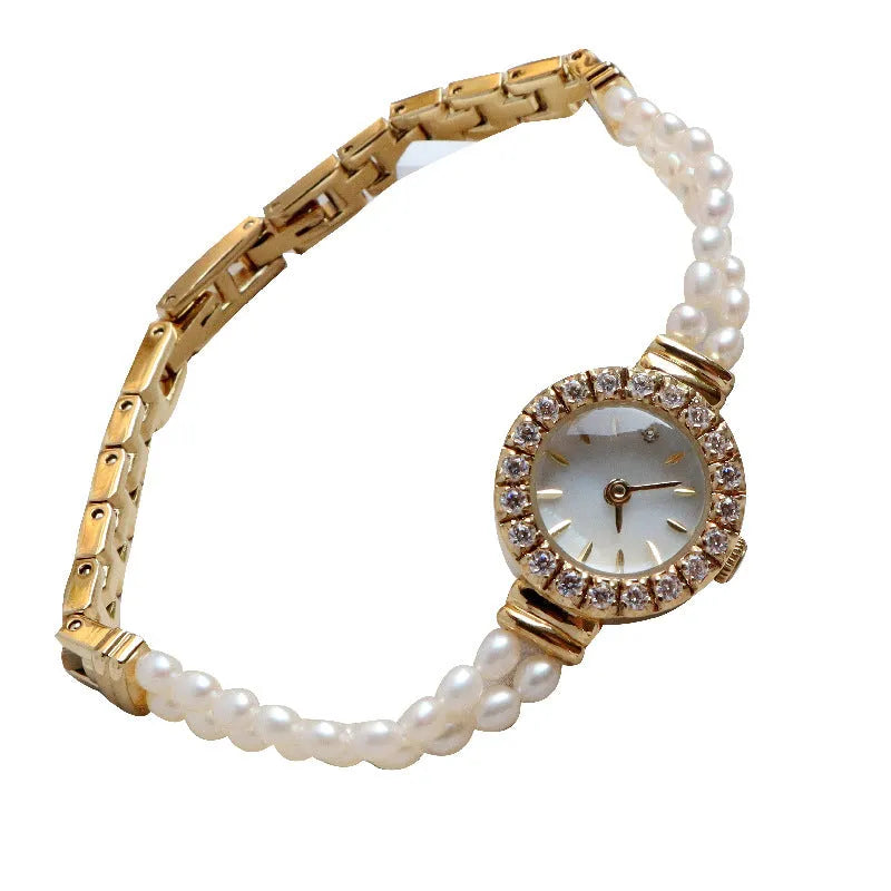 Women's light gold bracelet watch with freshwater pearls on stainless steel strap and 18mm dial.