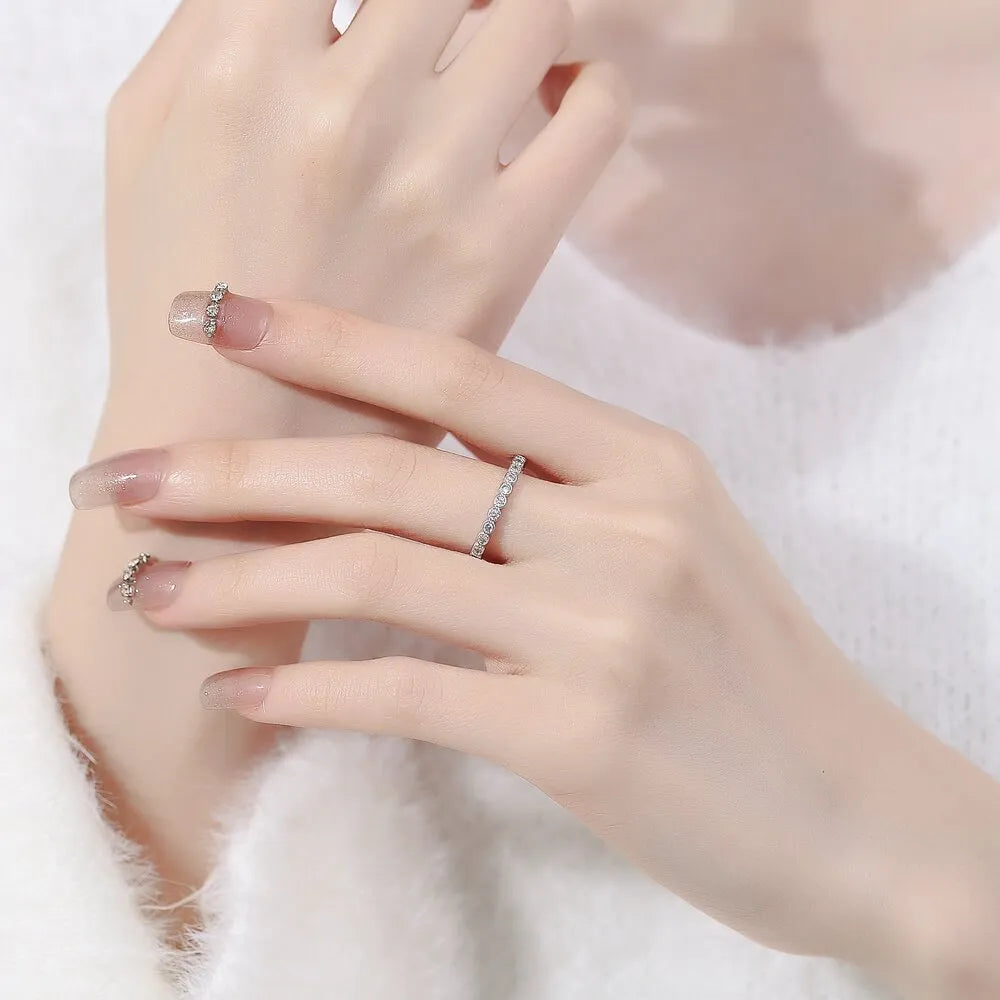 Geometric open mouth copper ring in electroplated white gold colour on a model's hand.
