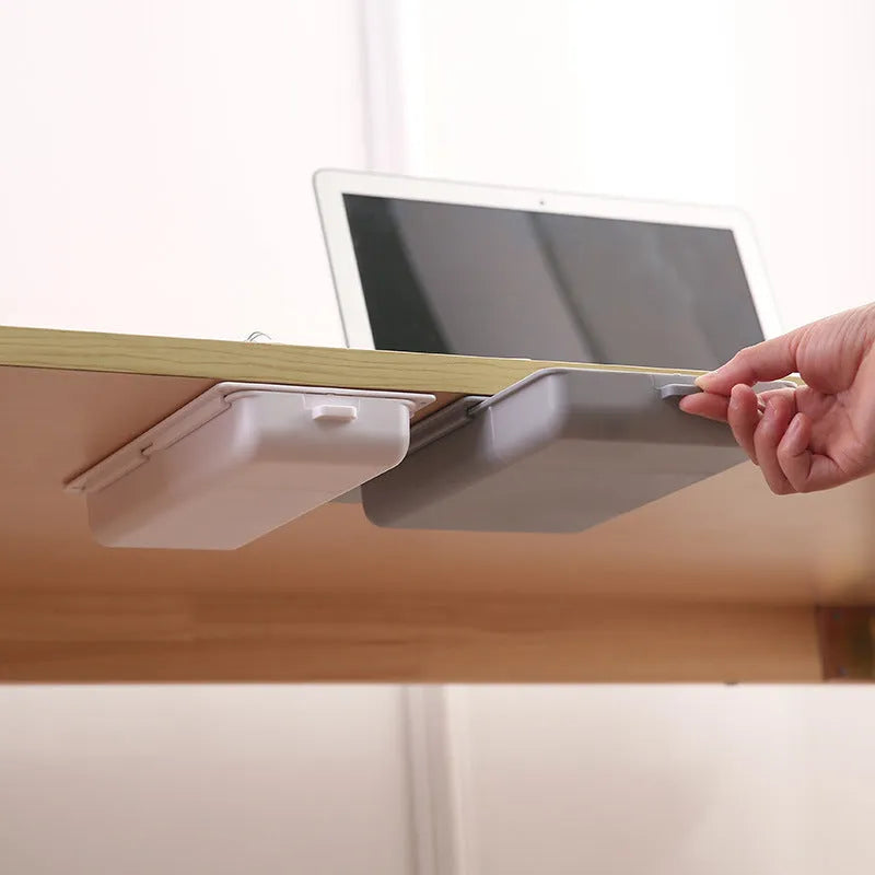 Small white plastic storage box with a lid and grid interior, mounted under a wooden table.