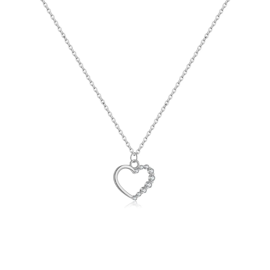 Close-up of a hollow heart-shaped sterling silver pendant on an oval chain, shown in both gold and white gold plated finishes.