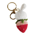 Hand-woven white rabbit strawberry pendant with keychain on grey background