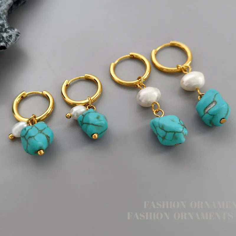 A pair of geometric turquoise and cultured pearl ear clips on a copper setting.