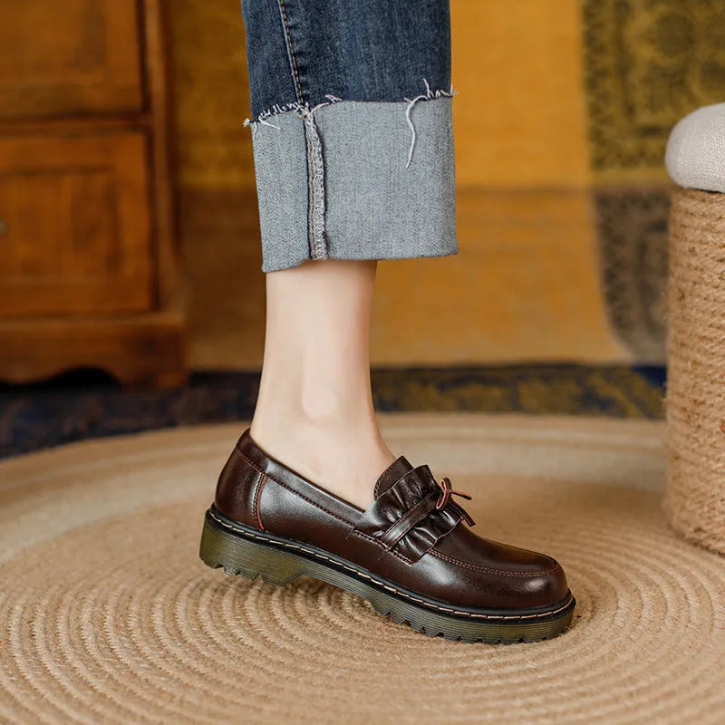 Women's black leather ankle boots with round toe and flat chunky heel, shown from the side.