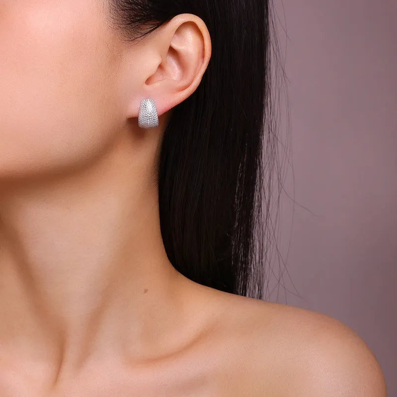 A pair of geometric sterling silver ear studs with moissanite stones for women.