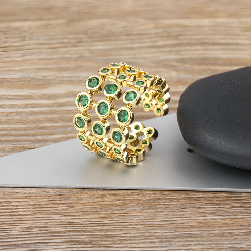 Copper ring with 18K gold plating, green zircon stones, and exaggerated three-layer wide band design.