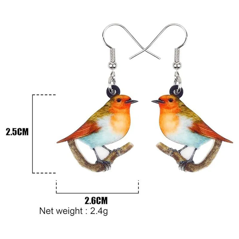 A pair of blue titmouse bird pendant earrings made from clear acrylic with geometric shapes and snake chain links.