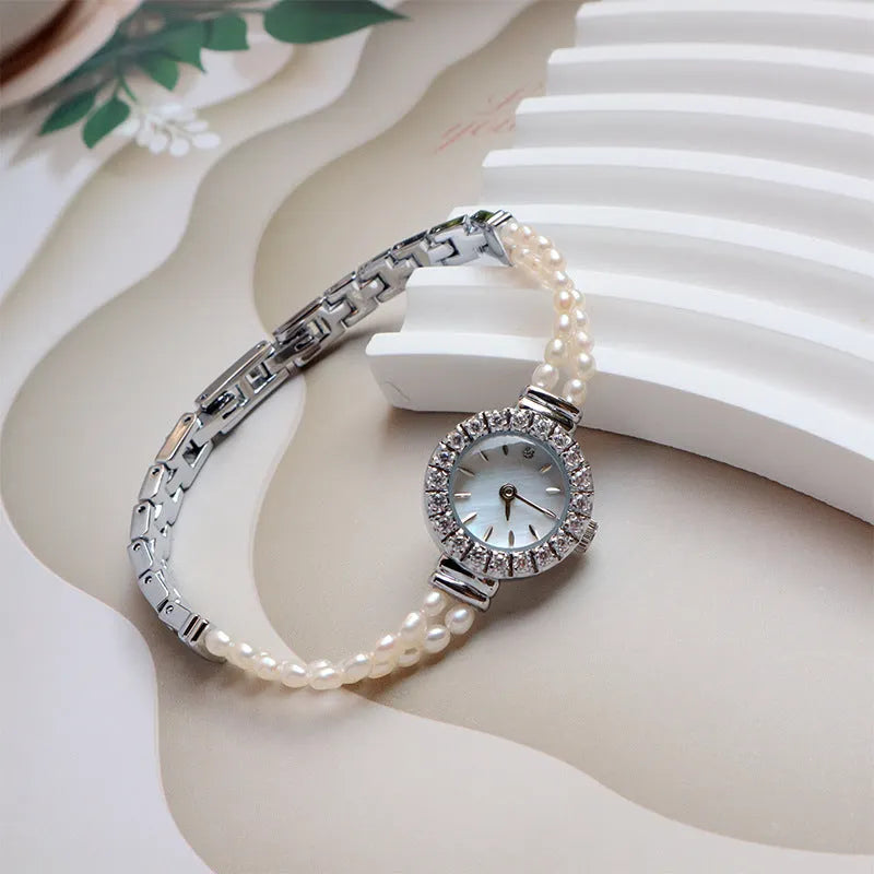 Women's light gold bracelet watch with freshwater pearls on stainless steel strap and 18mm dial.