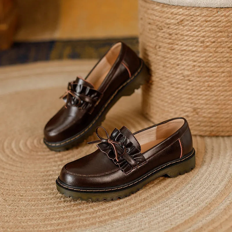 Women's black leather ankle boots with round toe and flat chunky heel, shown from the side.
