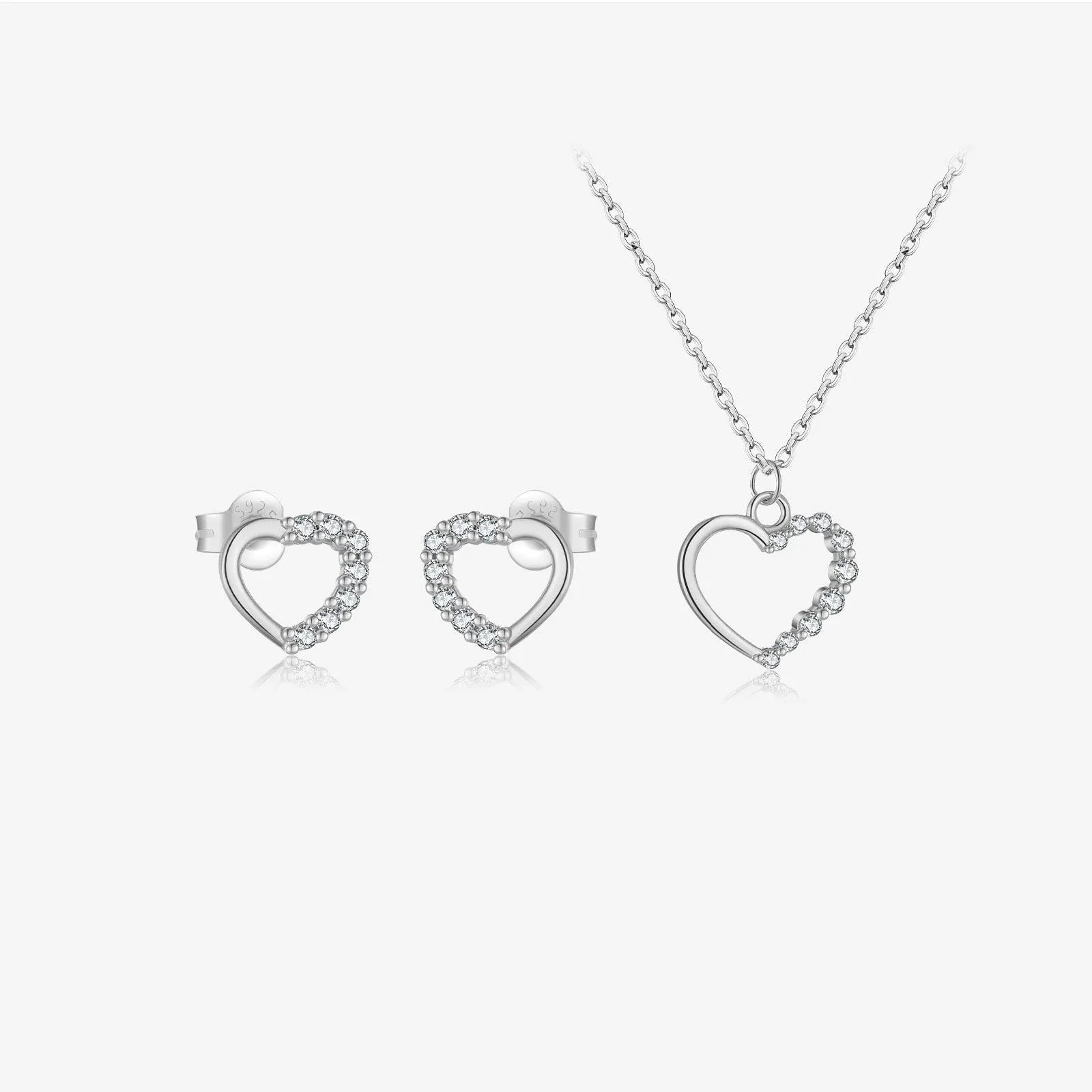 Close-up of a hollow heart-shaped sterling silver pendant on an oval chain, shown in both gold and white gold plated finishes.