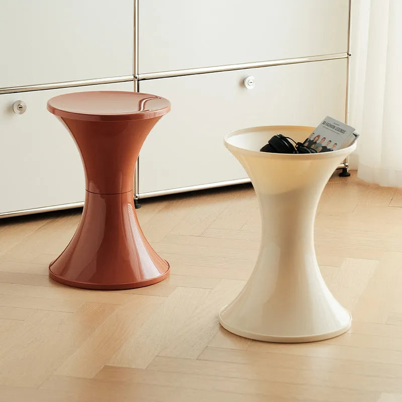 Plastic hourglass style shoe changing stool in green, shown in a home setting.