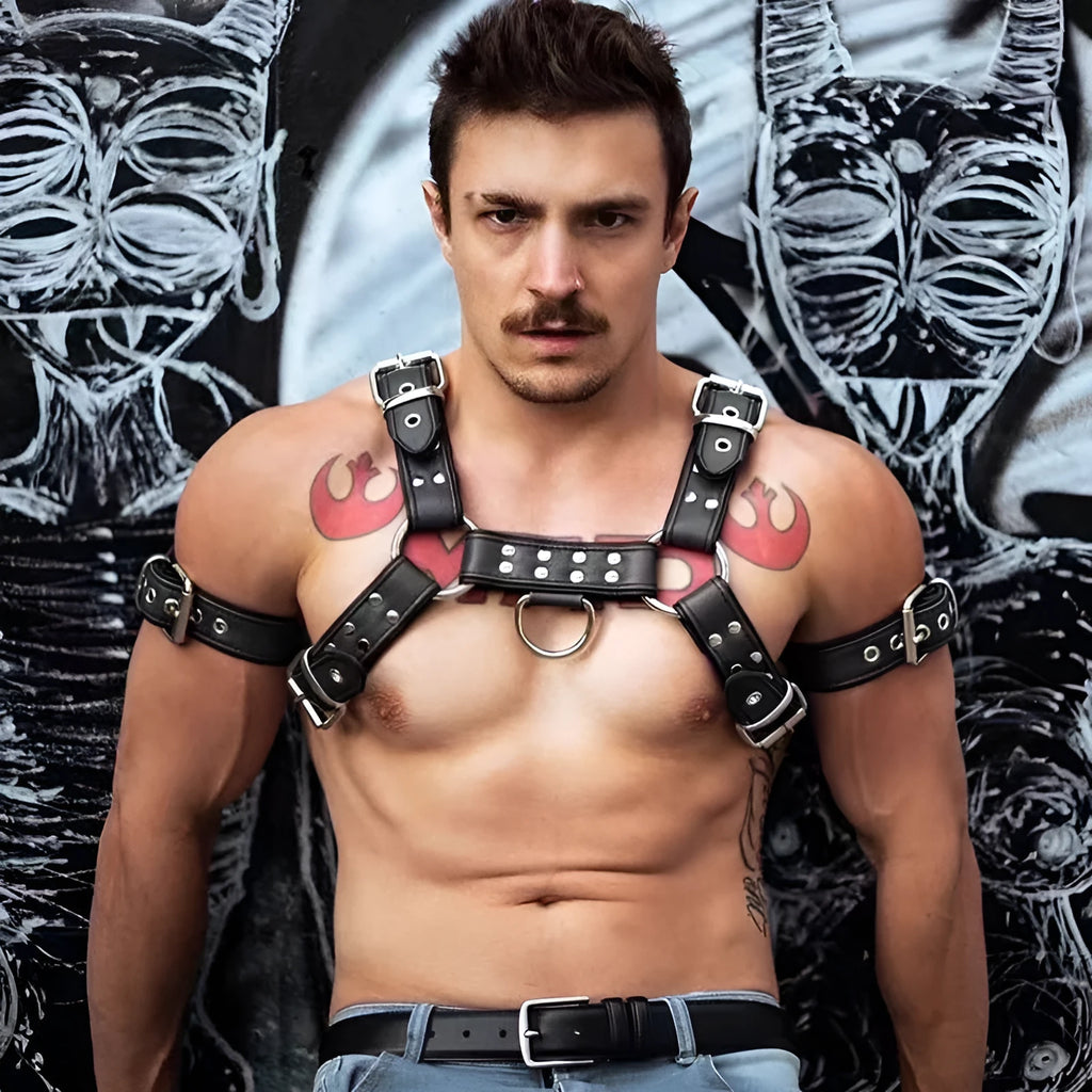 Black leather men's chest bondage strap with a large metal adjustment buckle.