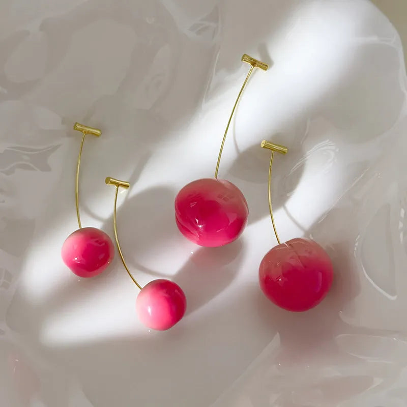 A pair of acrylic peach-shaped earrings on copper findings, shown in small and large size options.