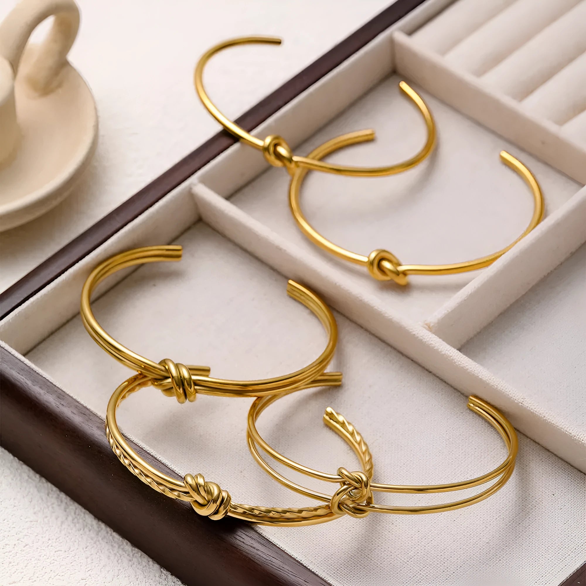 Gold or silver adjustable stainless steel women's bracelet with a C-shaped open design and double-layer knots.