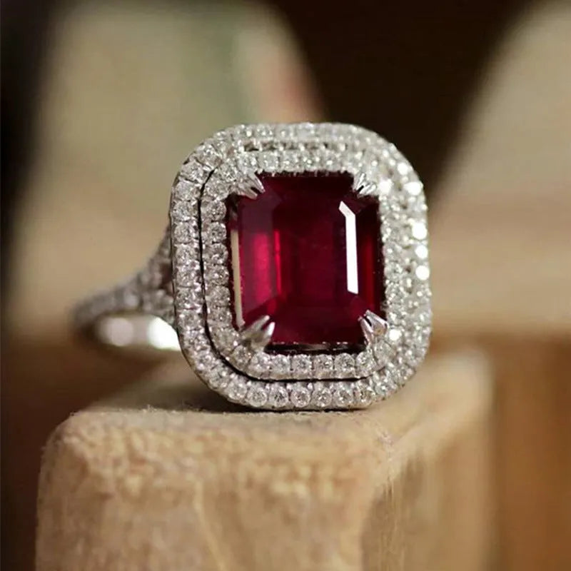 Women's red copper square ring with rhinestone geometric design on a finger.
