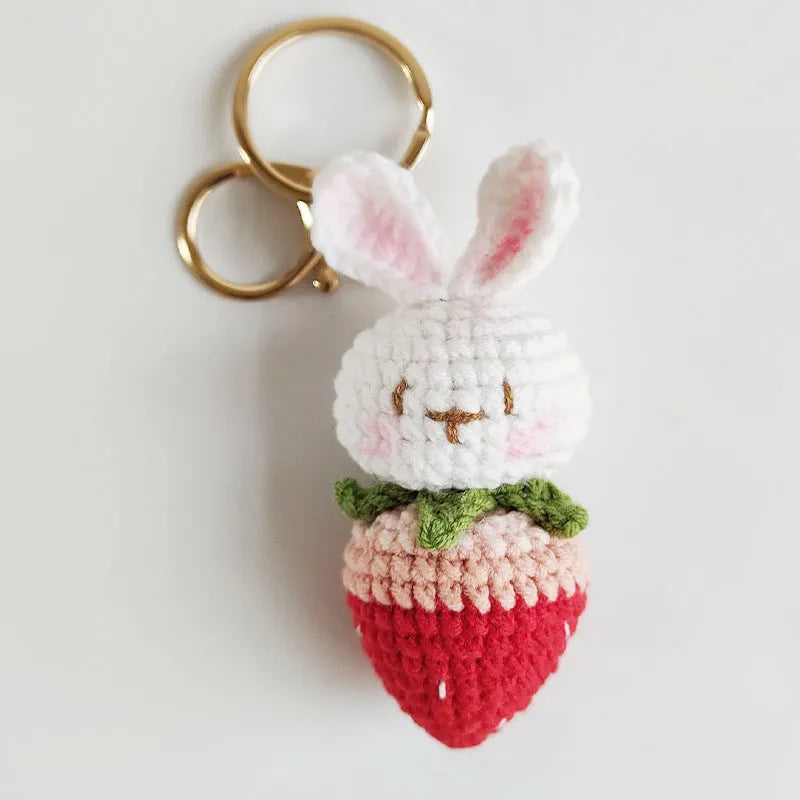 Hand-woven white rabbit strawberry pendant with keychain on grey background