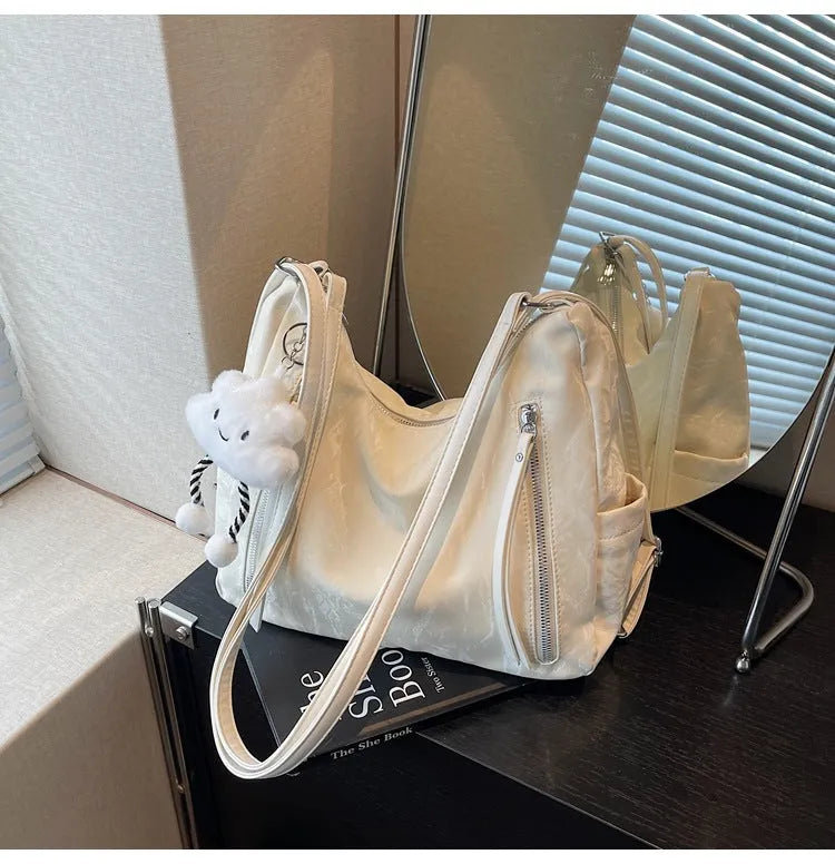 Women's PU leather fashion backpack in beige, black, blue, or silver with pendant accessory