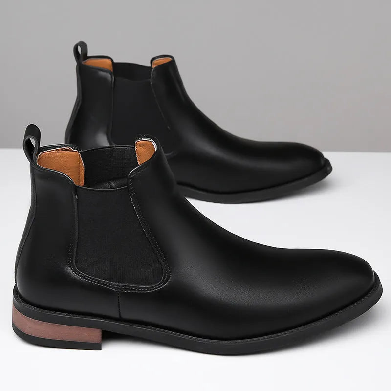 Men's black Chelsea high-top boots with a pointed toe and low rubber sole on a white background.