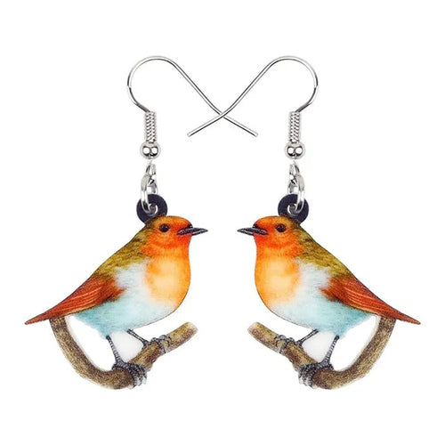 A pair of blue titmouse bird pendant earrings made from clear acrylic with geometric shapes and snake chain links.