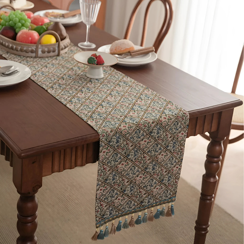Dark blue Nordic jacquard table flag with striped bouquet pattern and tassel fringe on a wooden table.