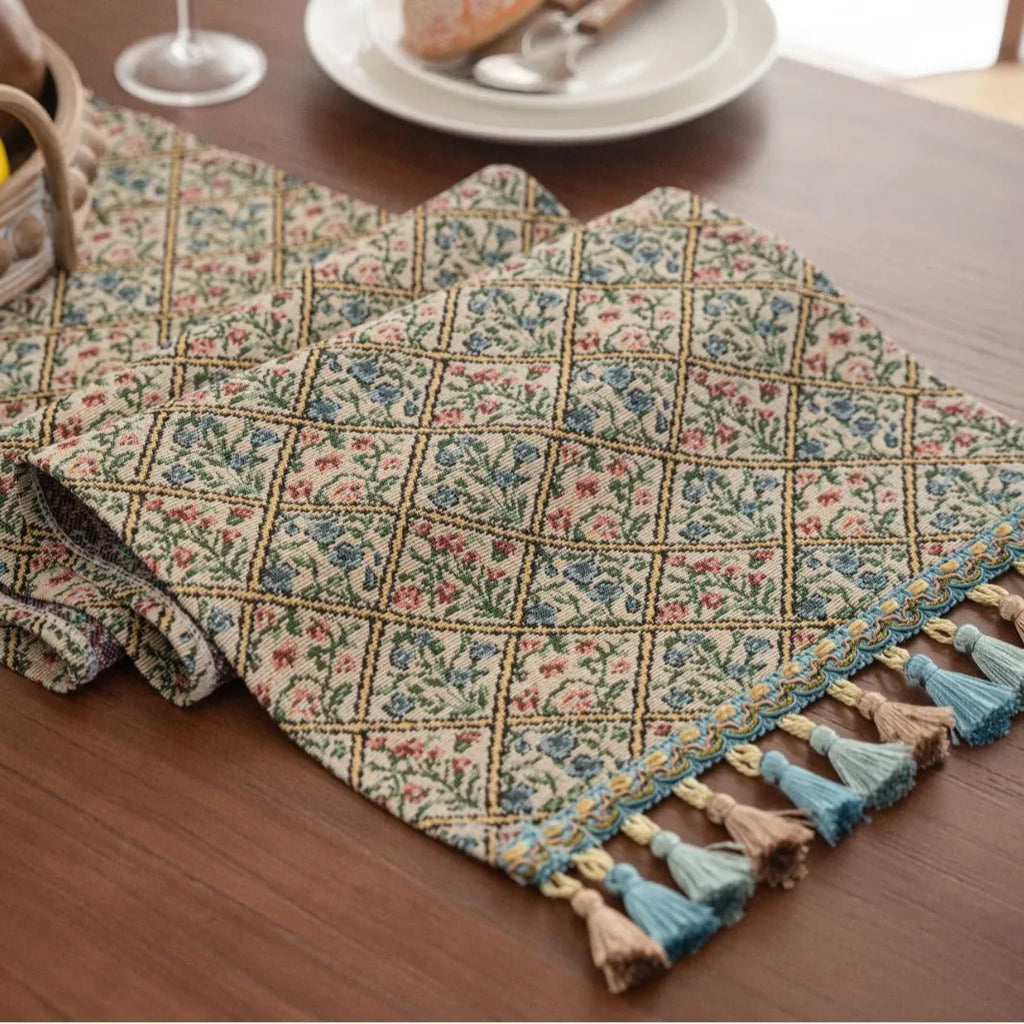 Dark blue Nordic jacquard table flag with striped bouquet pattern and tassel fringe on a wooden table.