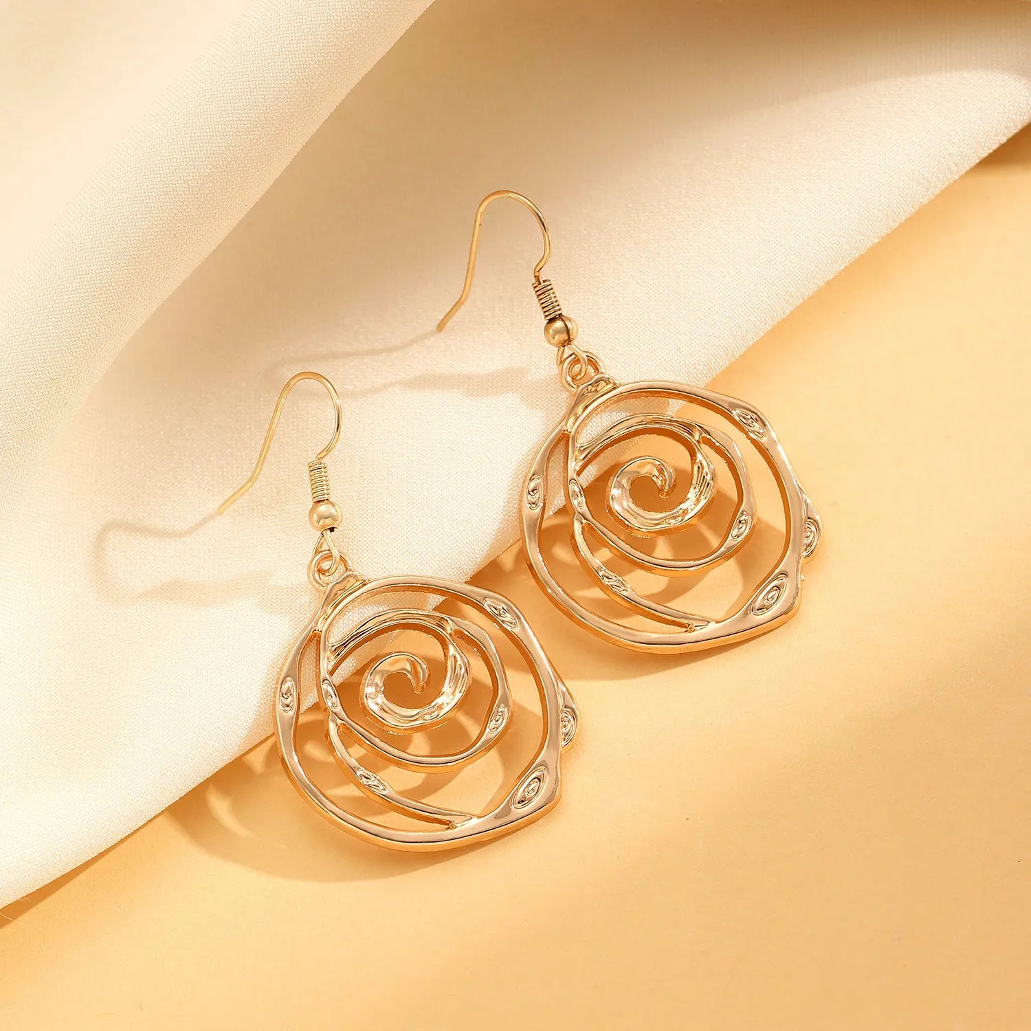 Spiral donut jewellery set showing necklace, bracelet and earrings in gold colour with geometry shapes