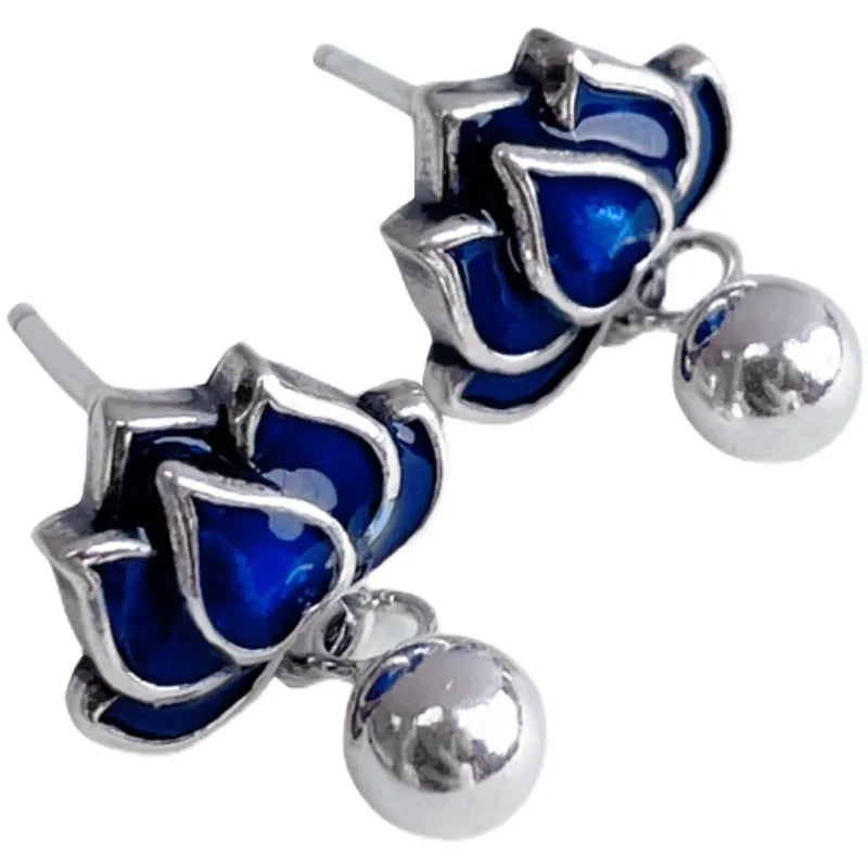 Silver-toned alloy lotus flower earrings with seedpod centre and dangling tassels on a white background.