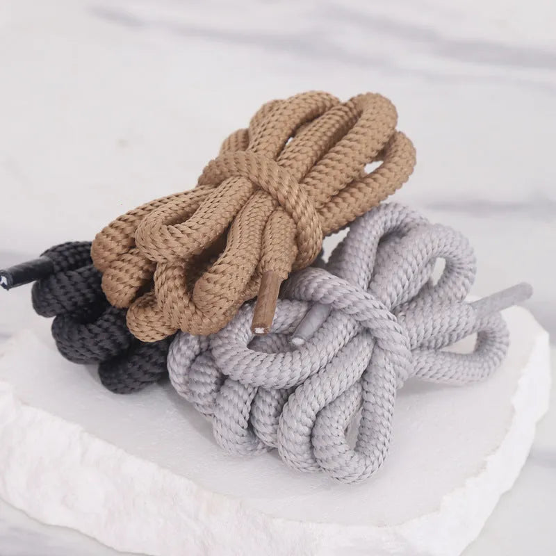 Oval round shoelace in multiple colours showing 1.0cm width, next to a sneaker.