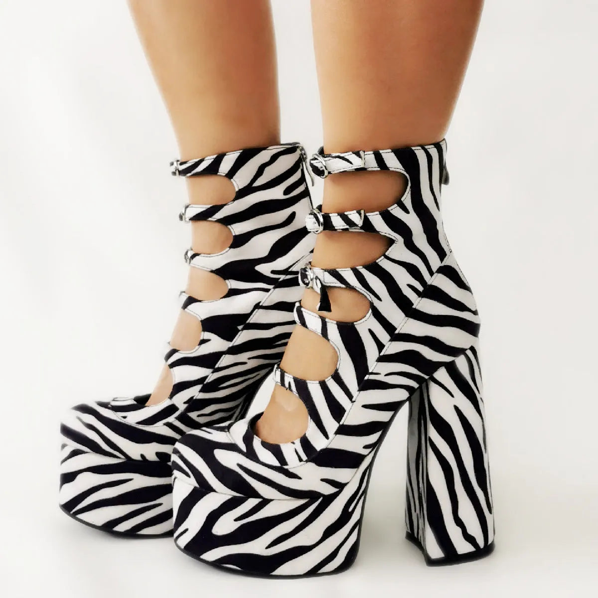 Black patent leather women's platform ankle boots with a thick heel and serpentine buckle strap.