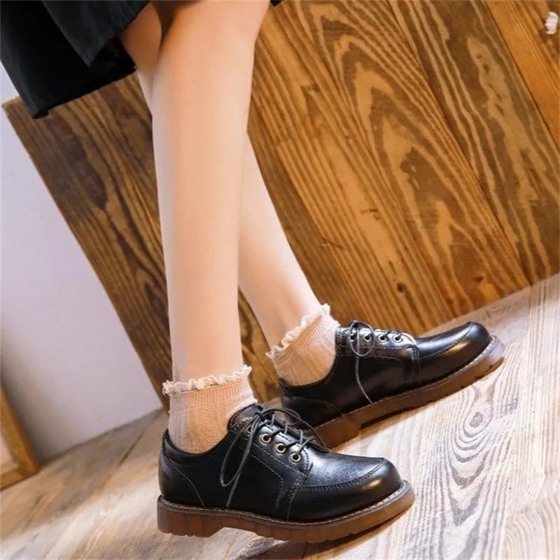 Women's black retro Mary Jane pumps with front lace-up and low square heel on a white background.