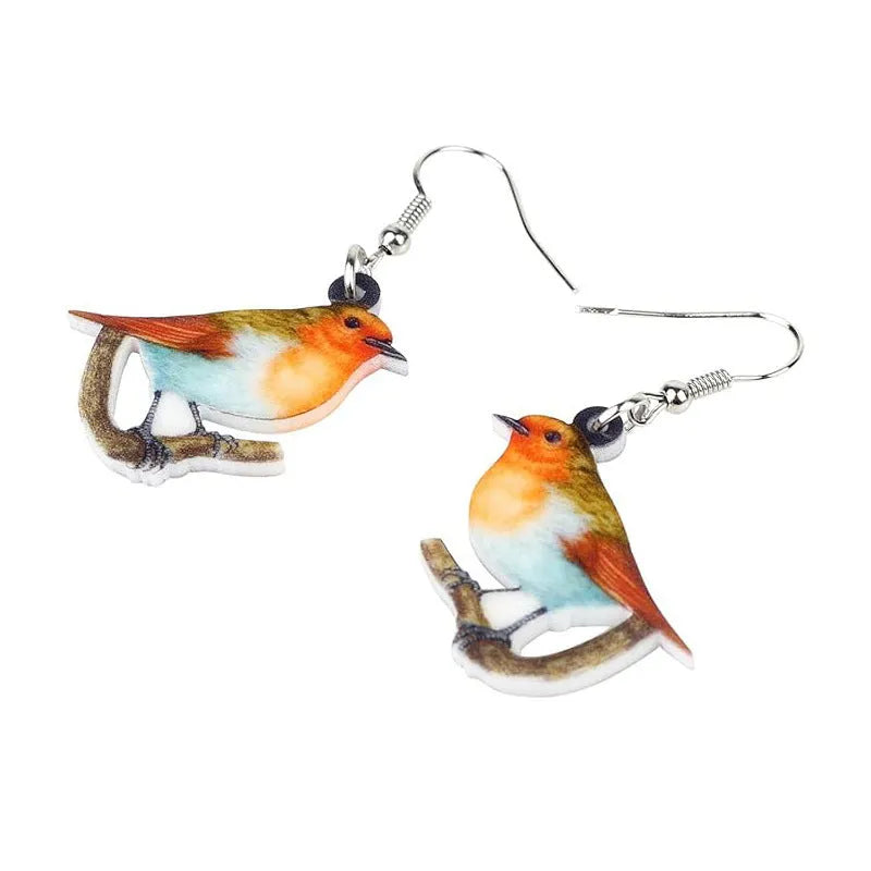 A pair of blue titmouse bird pendant earrings made from clear acrylic with geometric shapes and snake chain links.