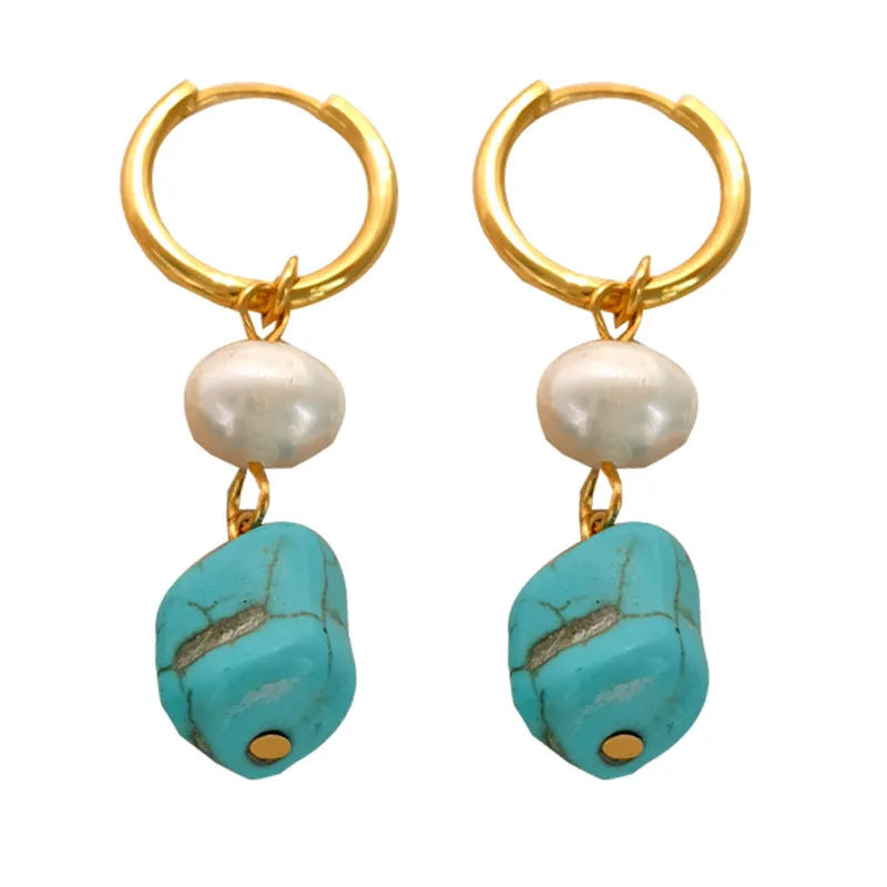 A pair of geometric turquoise and cultured pearl ear clips on a copper setting.