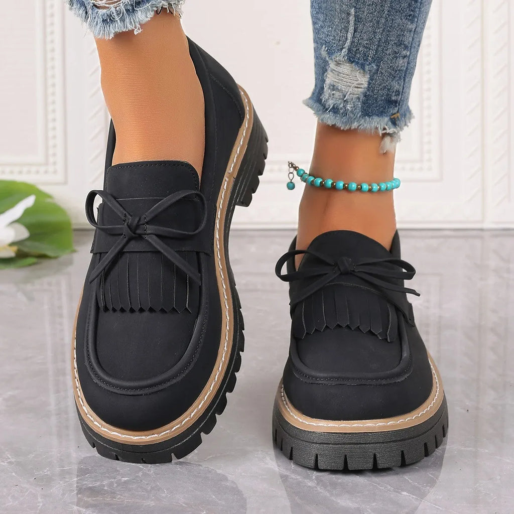 Women's black plus size loafer with tassel and bow decoration on a chunky rubber sole