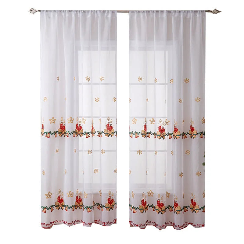 Pair of white Christmas curtains with red and green embroidered snowflakes, shown hanging in a window.