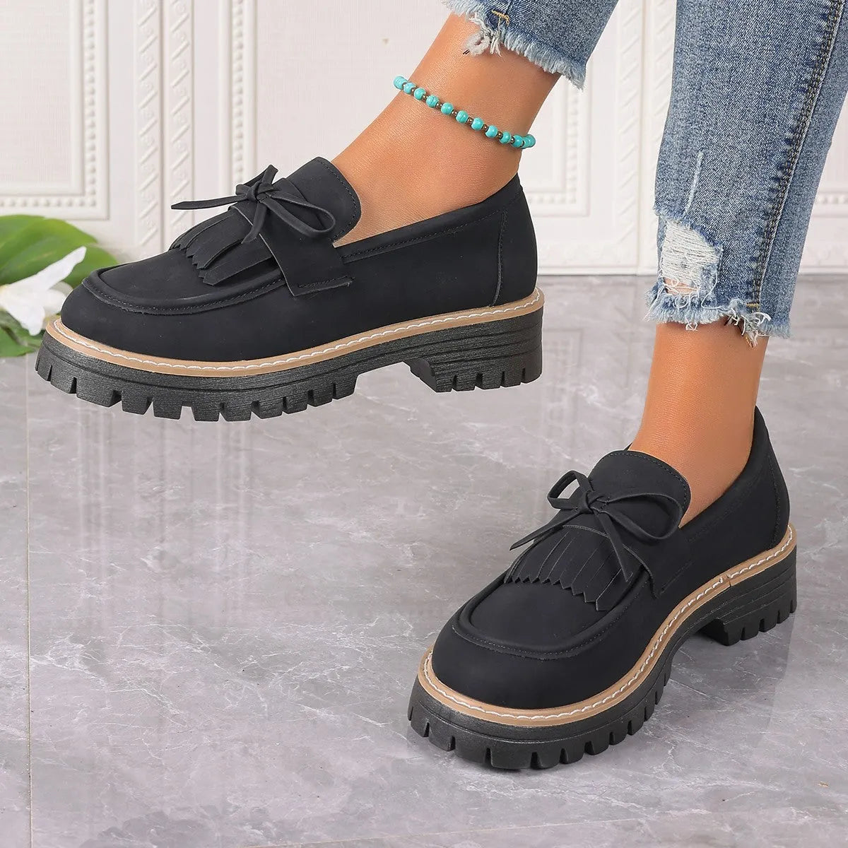 Women's black plus size loafer with tassel and bow decoration on a chunky rubber sole