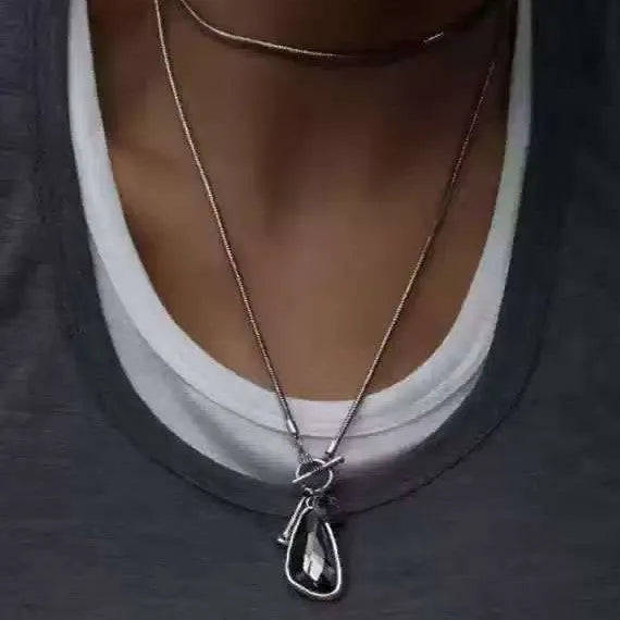 Long women's necklace with geometric pendant on snake bones chain