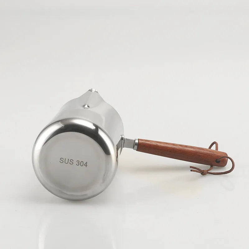 Stainless steel coffee cup with wooden handle showing interior measurement scale markings