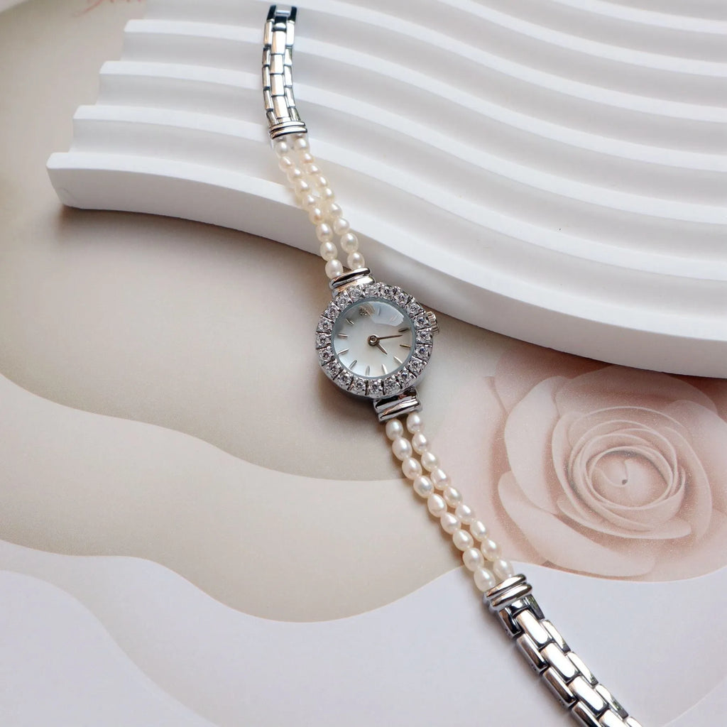 Women's light gold bracelet watch with freshwater pearls on stainless steel strap and 18mm dial.
