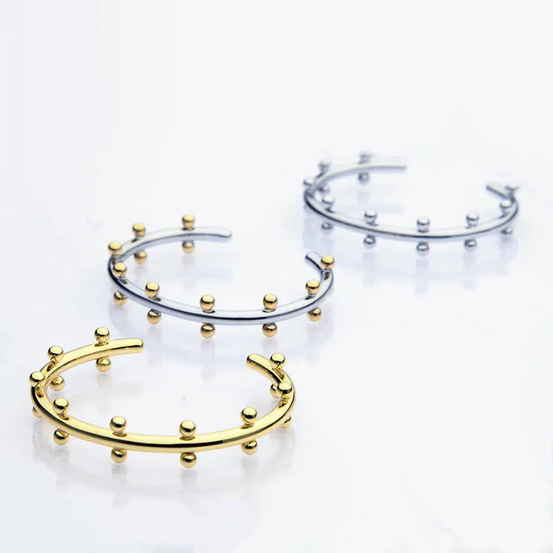 Stainless steel C-shaped bean beads with texture rivet detail in gold, steel, and steel gold colours.