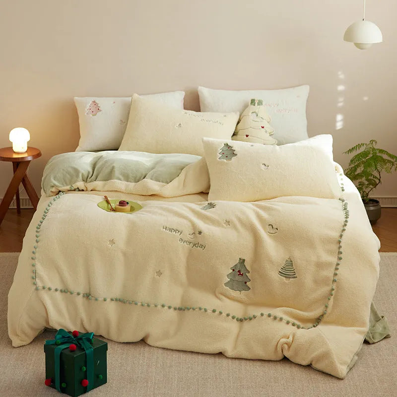 Winter milk fibre bedding four-piece set with green Christmas tree pattern on a bed.