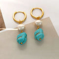 A pair of geometric turquoise and cultured pearl ear clips on a copper setting.