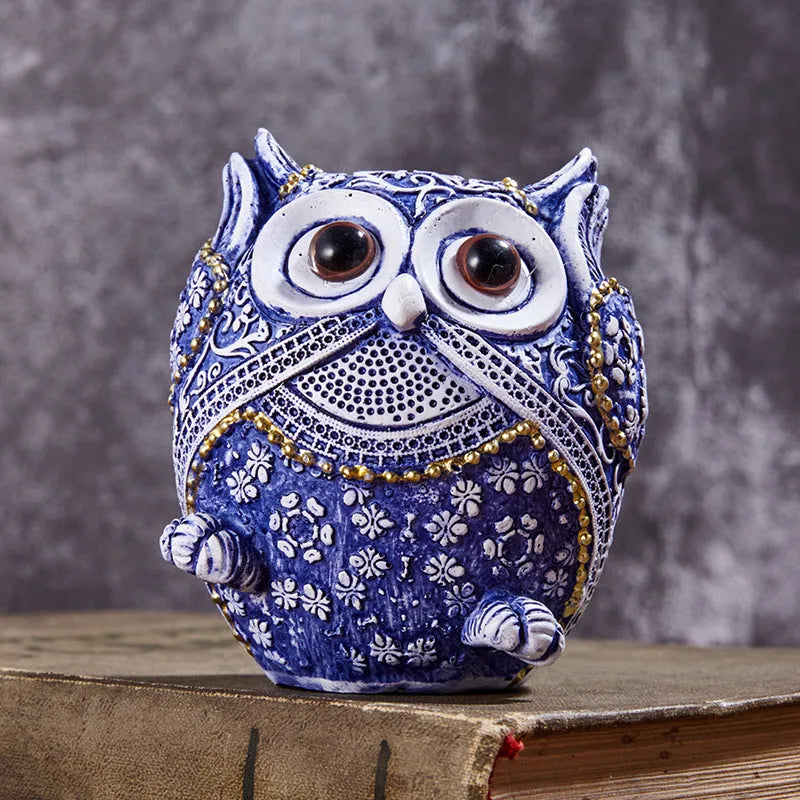 Three blue and white owl resin ornaments in large and small sizes on a white shelf