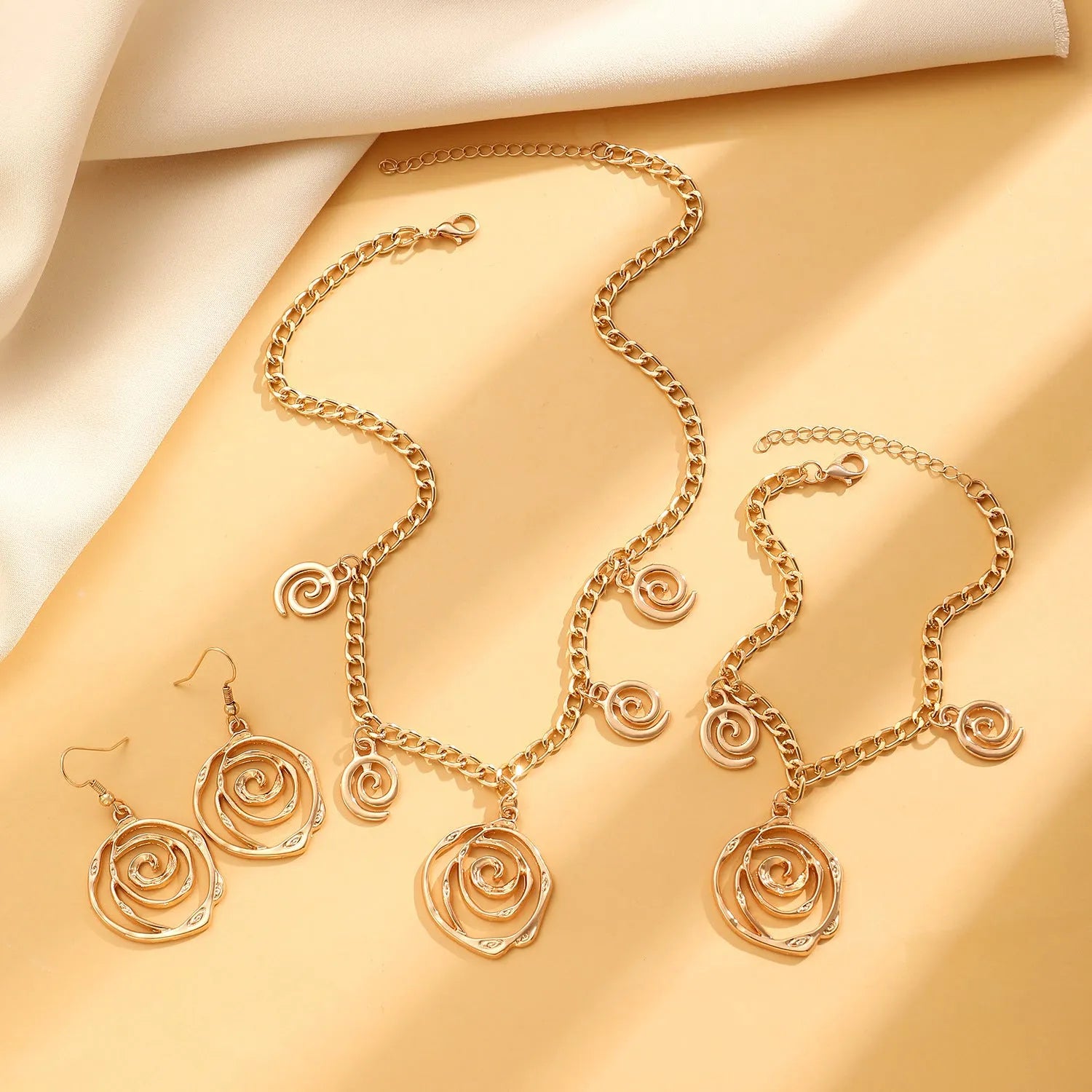 Spiral donut jewellery set showing necklace, bracelet and earrings in gold colour with geometry shapes