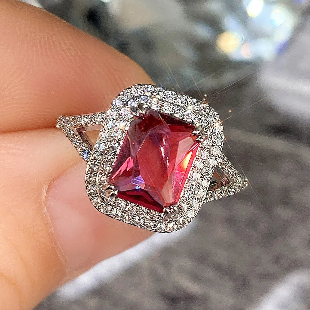 Women's red copper square ring with rhinestone geometric design on a finger.