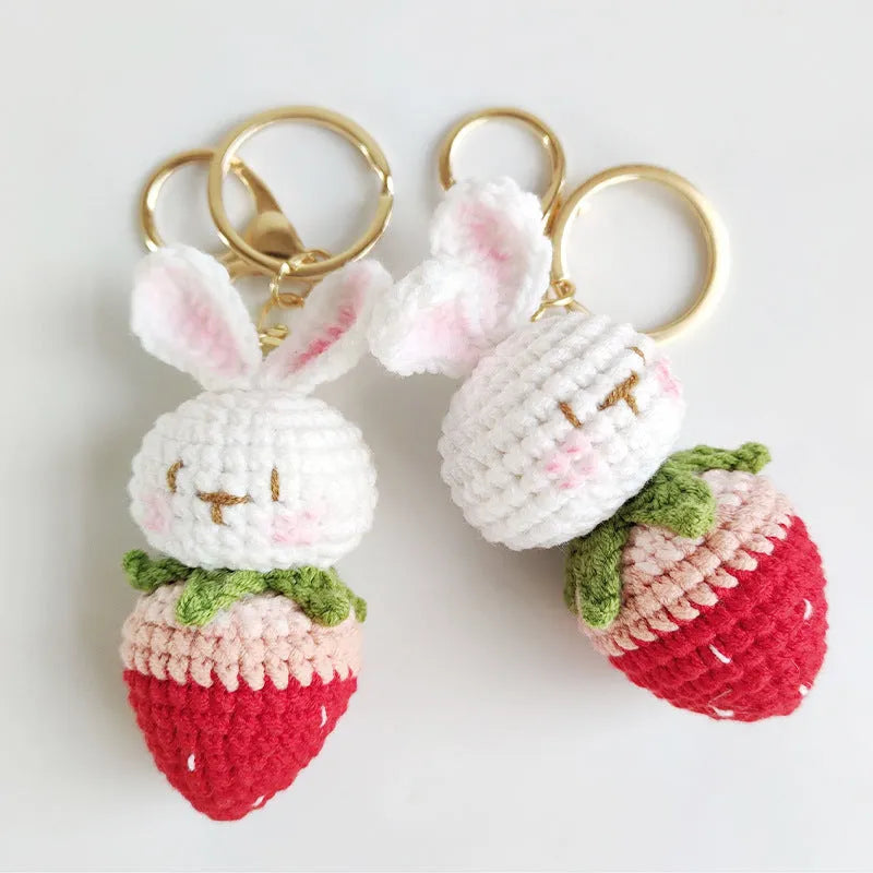 Hand-woven white rabbit strawberry pendant with keychain on grey background
